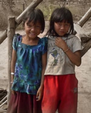 Two smiling girls posing in the Veal Thom village.