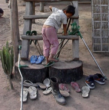 A child climbs around a display of shoes. One boot is centered.